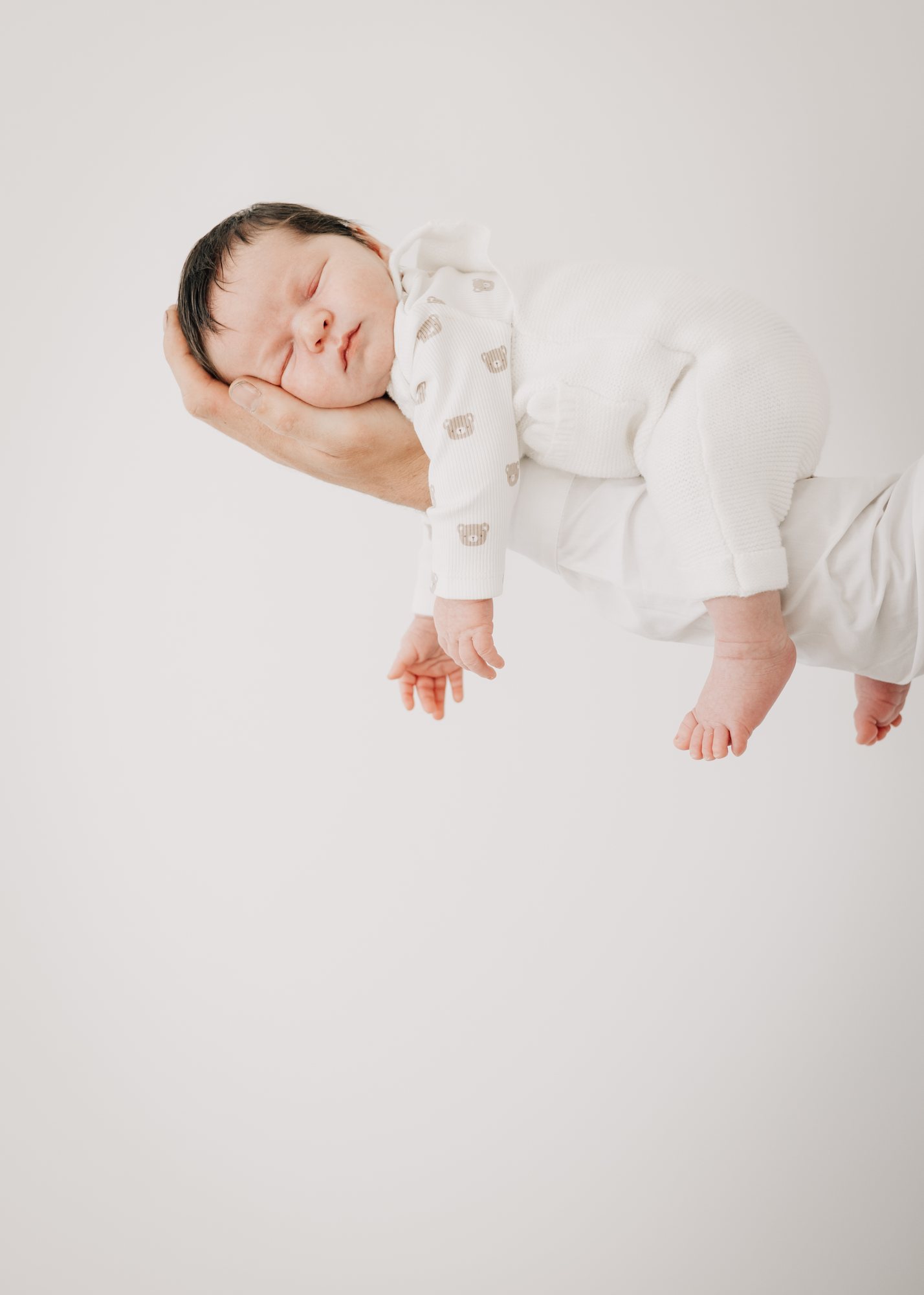 Newborn baby resting in a parent’s hands